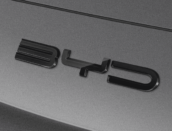 Side angle close-up of gloss black front bumper emblem decal installed on BYD Sealion 6, showcasing sleek 3D styling
