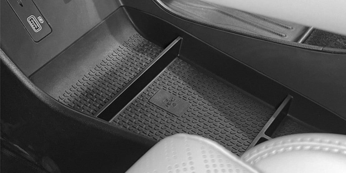 Close-up of BYD ATTO 2 (2025+) centre console lower storage tray organiser insert, showing textured anti-slip TPE surface and built-in dividers for neat, rattle-free storage.