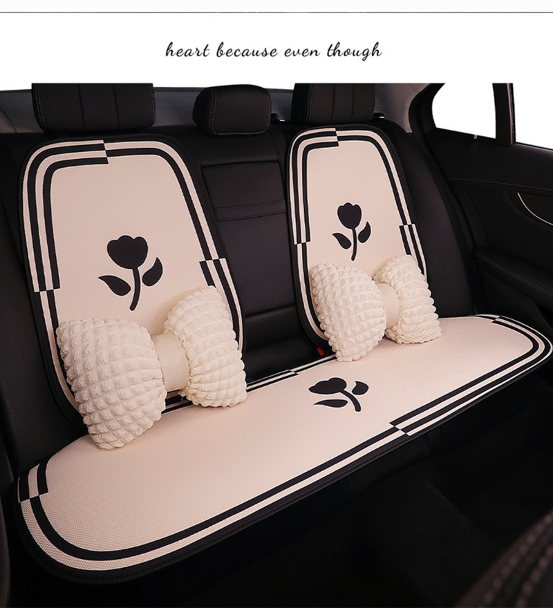 Rear seat view of BYD cartoon-style car seat cushions with flower pattern, including matching pillows, showcasing full coverage and elegant design.