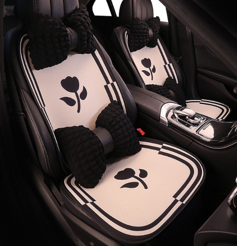 Breathable cartoon car seat cushions with flower pattern installed in BYD vehicle, featuring soft fabric and decorative bow-shaped pillows.
