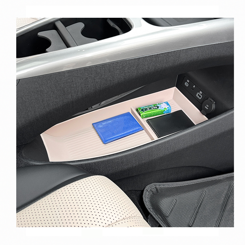 BYD Dolphin center console organizer tray holding wallet, tissues, and small items, showing organized car interior storage space.