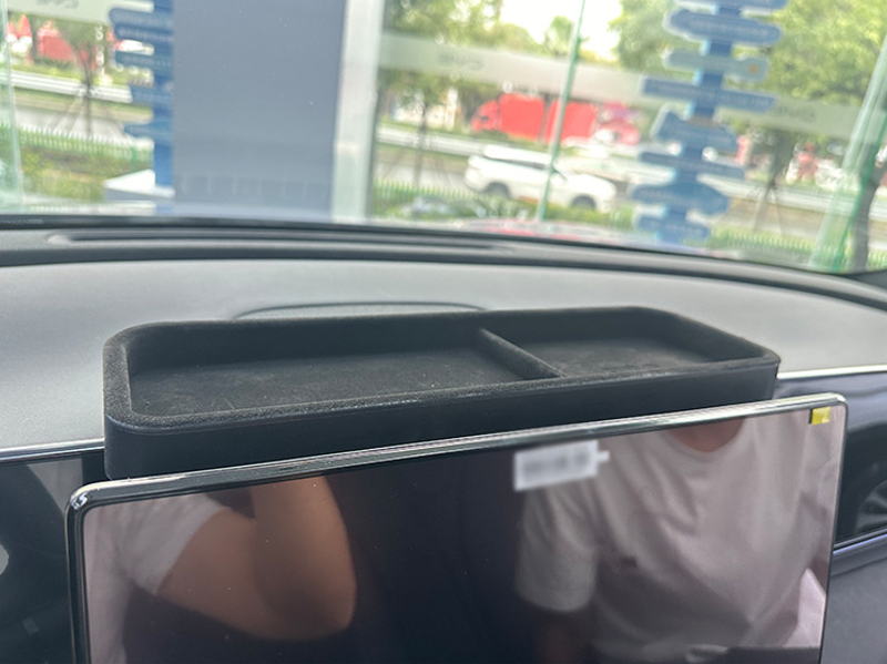 Installed view of BYD Seal dashboard rear organizer tray in black ABS, perfectly fitting behind touchscreen, providing hidden storage for keys, glasses, and small items