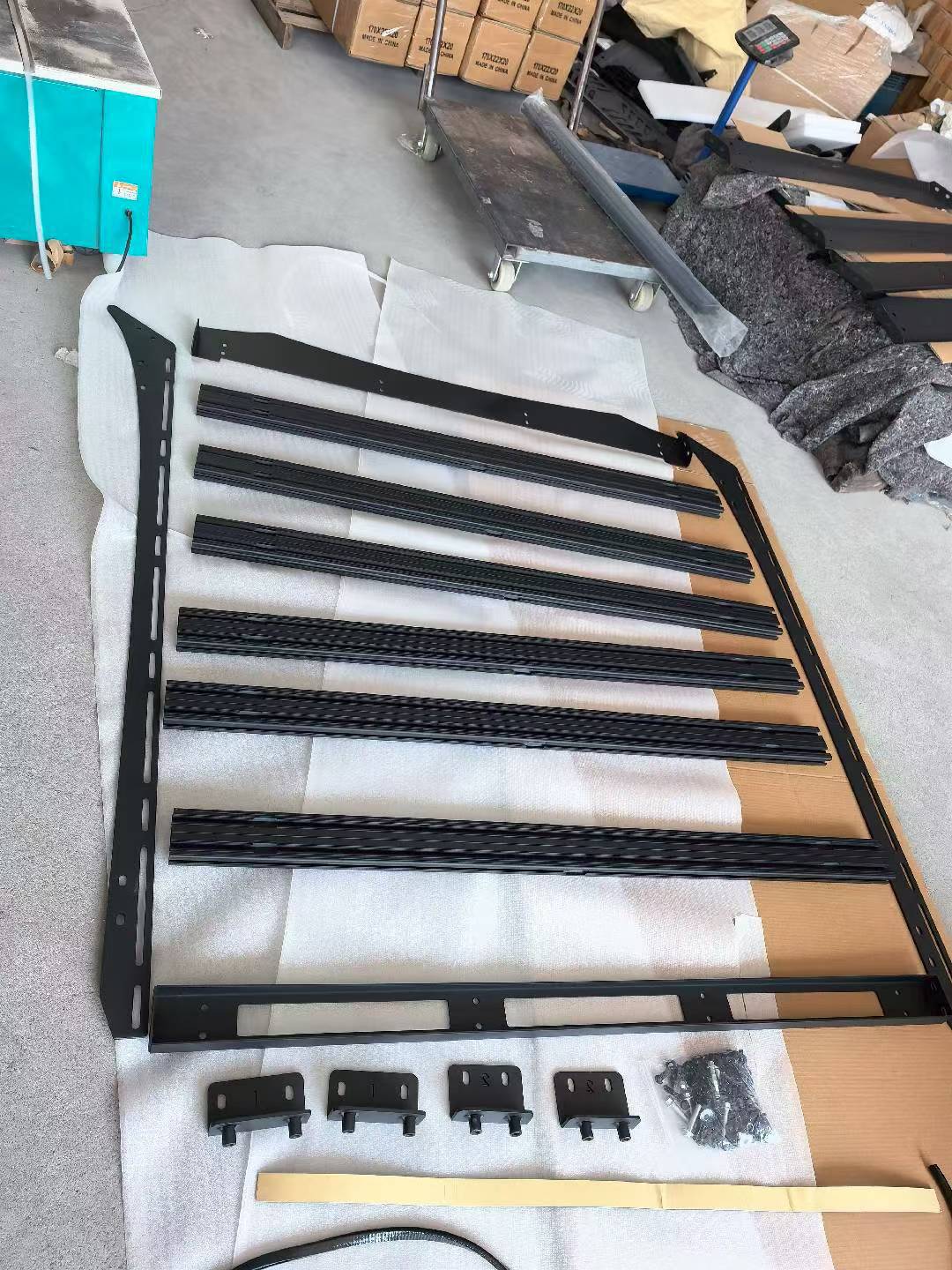 Unassembled BYD Shark 6 roof rack kit with aluminum crossbars and steel side frames. Includes mounting brackets and bolts. Ready for installation.