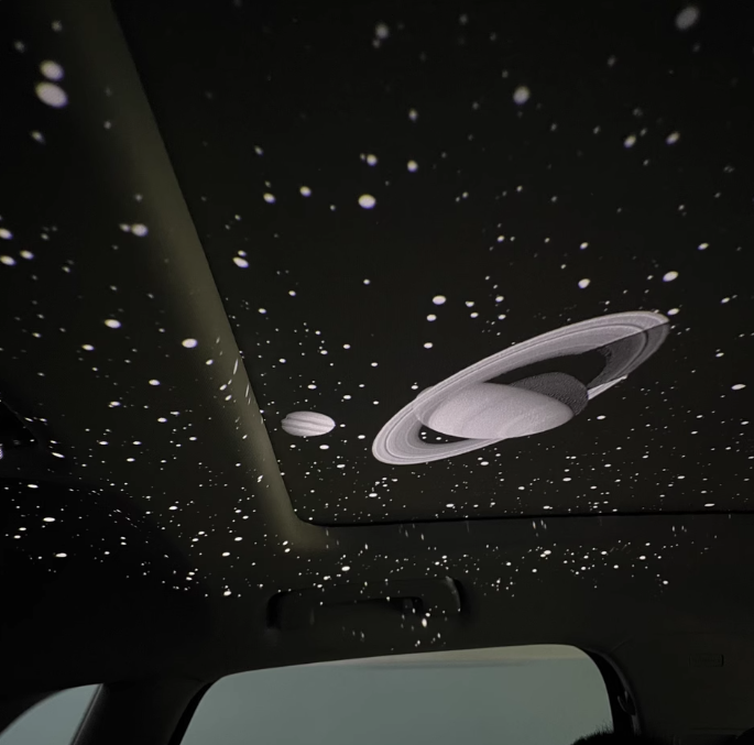 Car USB starlight projector displaying Saturn pattern on interior ceiling, creating ambient galaxy effect for night driving and car decoration.