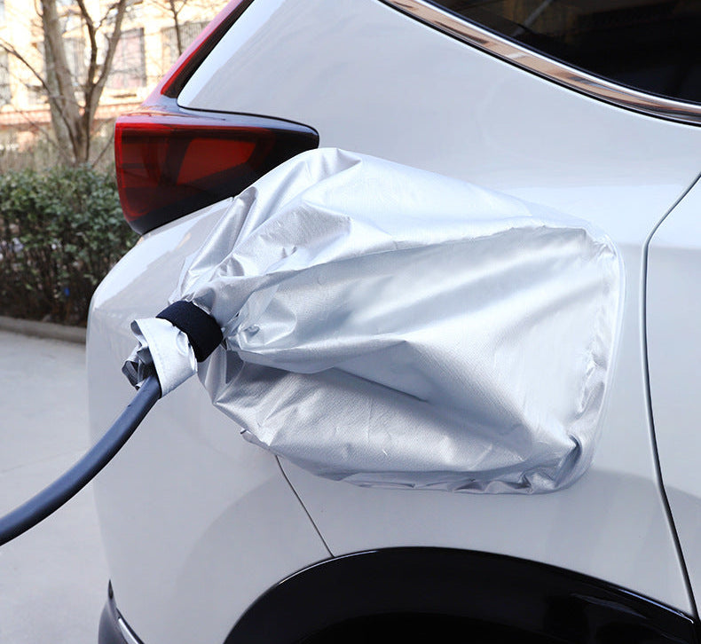 Silver outdoor EV charging port cover on a white BYD vehicle, designed to protect against rain, dust, and UV while charging.