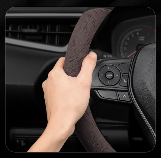 Close-up of hand gripping a suede steering wheel cover – soft texture, anti-slip design for secure driving control