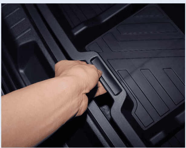 Close-up of a hand lifting the BYD Sealion 6 underfloor trunk organizer using built-in handle for easy access and storage

