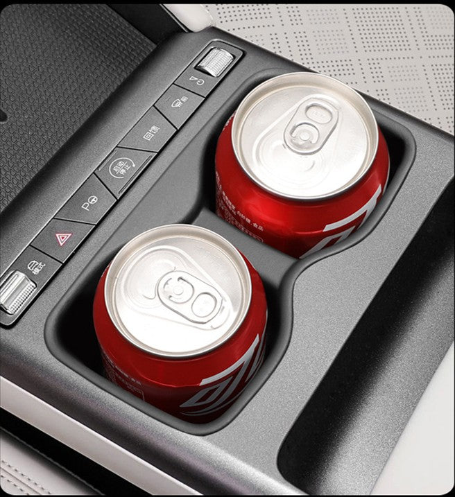 Two drink cans sitting securely in the BYD ATTO 2 (2025+) centre console cup holder with a non-slip TPE cup holder insert installed, designed to reduce rattles, prevent spills and protect the cup holder surface.