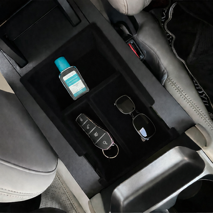 Installed BYD ATTO 2 (2025+) centre console organiser insert in the armrest storage, showing divided compartments holding keys, sunglasses and hand sanitiser for a tidy, easy-to-reach interior (BYDream).