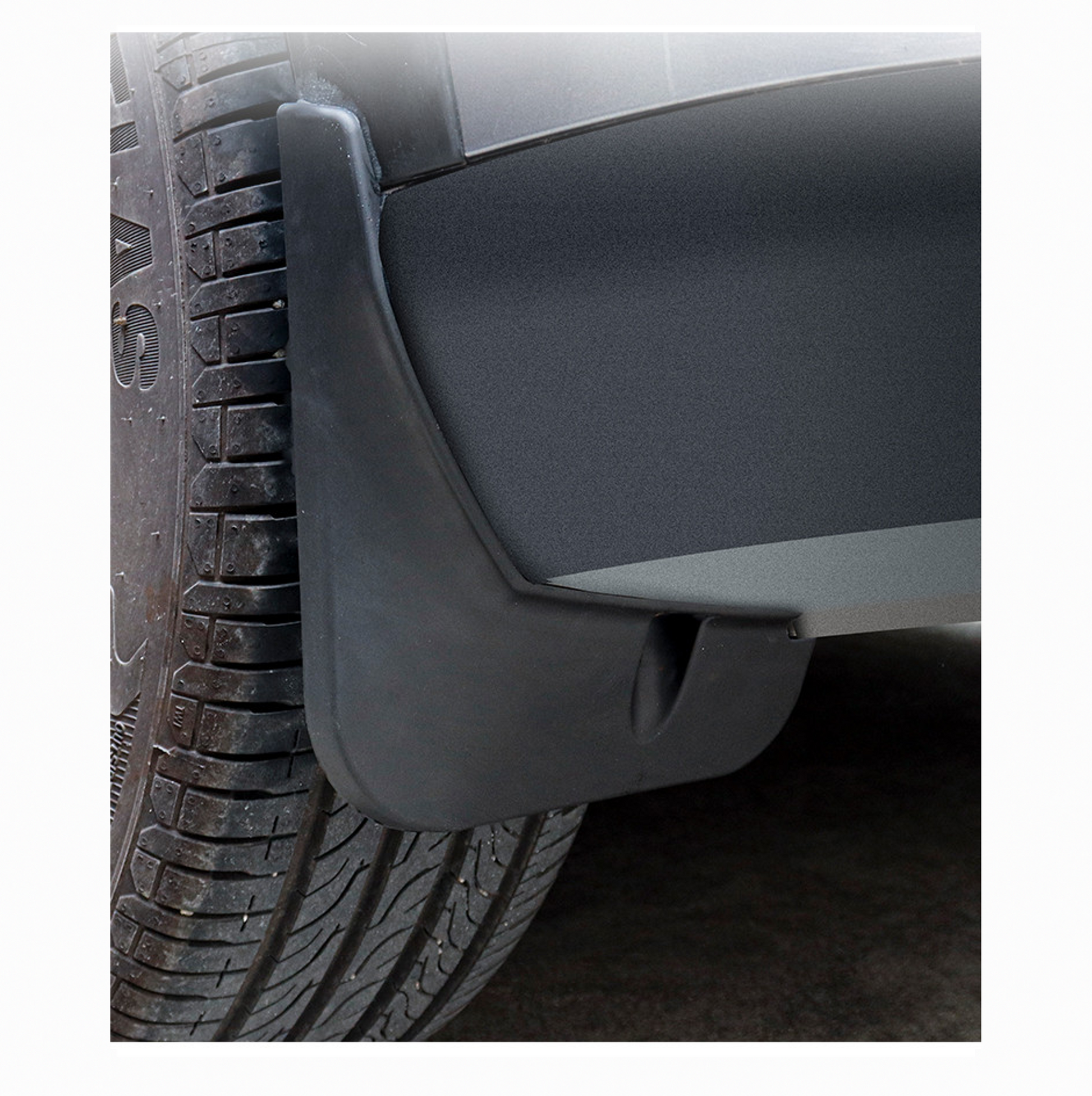 Close-up view of a black mudguard installed behind the wheel of a BYD ATTO 3, showing texture and fit.