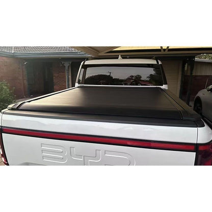 `BYDREAM aluminum retractable tonneau cover for white BYD Shark 6, rear straight view installed on driveway`